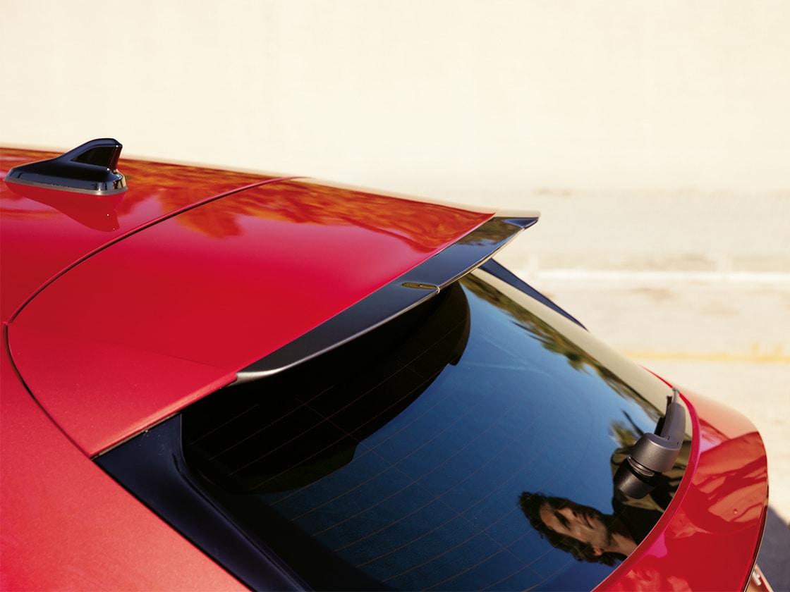 Red SEAT Leon with a sporty roof spoiler, enhancing aerodynamic flow and performance for the entry-level or advanced trims.