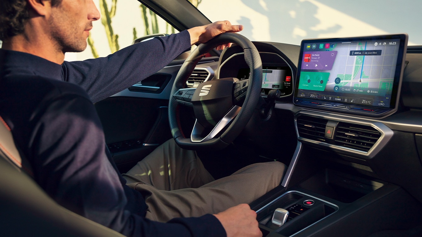 Driver interacting with the dynamic seat dashboard touchscreen, featuring navigation and advanced controls.