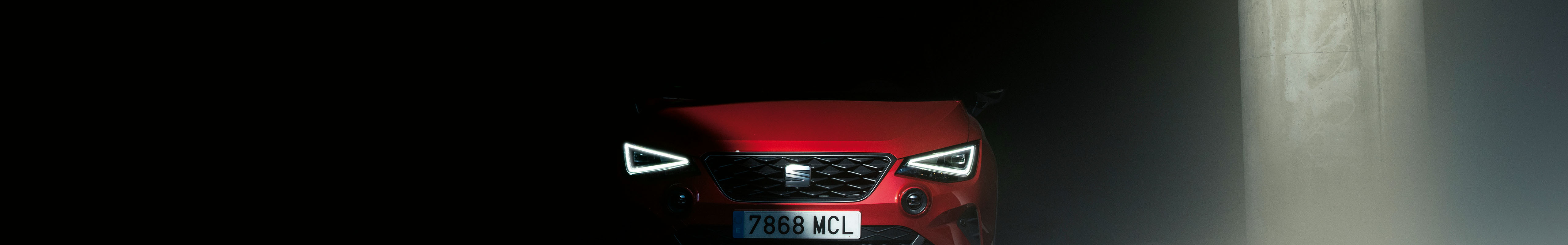 A red seat car in a dimly lit, moody environment, positioned as the hero image for customer support