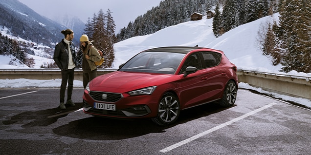 red seat leon in a winter mountain setting, emphasising sustainability and adaptability for hybrid car drivers