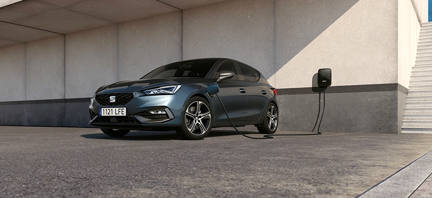 Seat leon in blue charging via wall charger, stairs, low angle