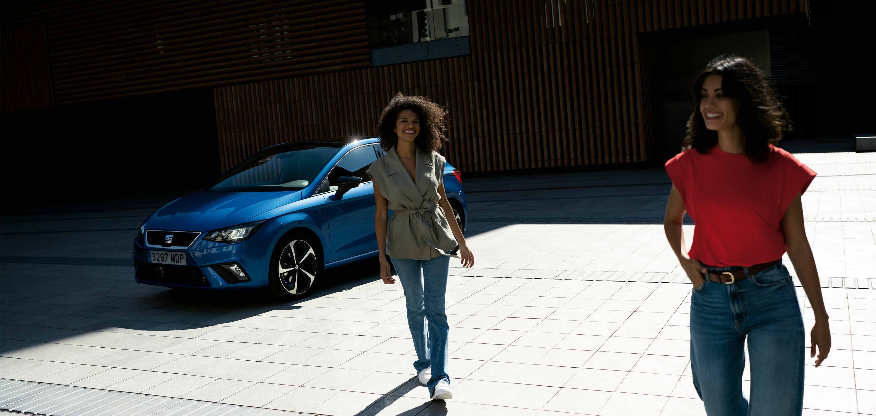 Customised seat ibiza in sapphire blue with seat care, two models walk in front of the vehicle smiling. 