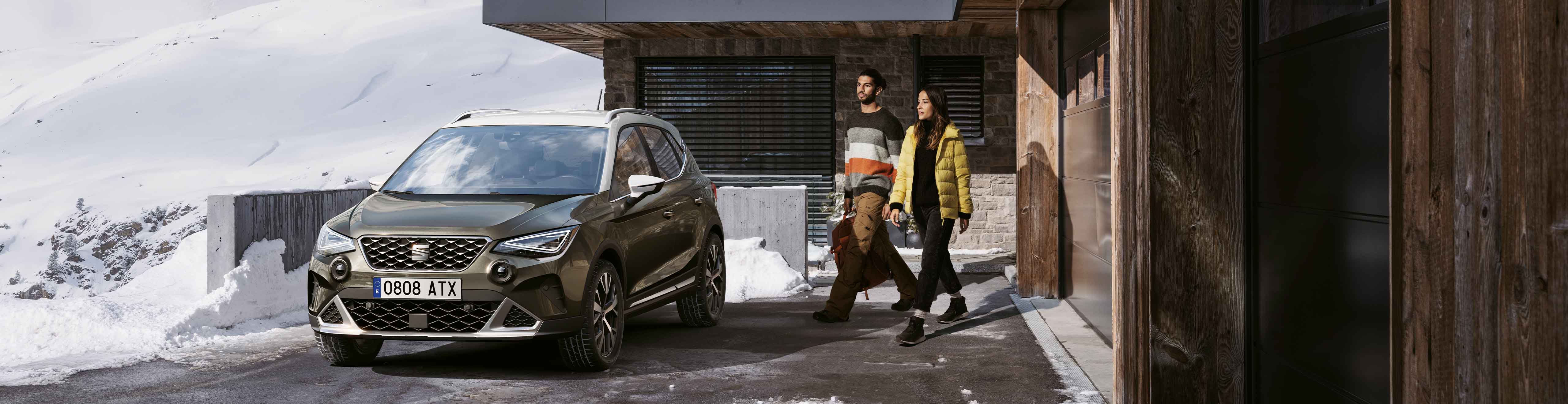 Seat ateca with new car accessories, seat genuine accessories in the snowy mountains and wooden building. 