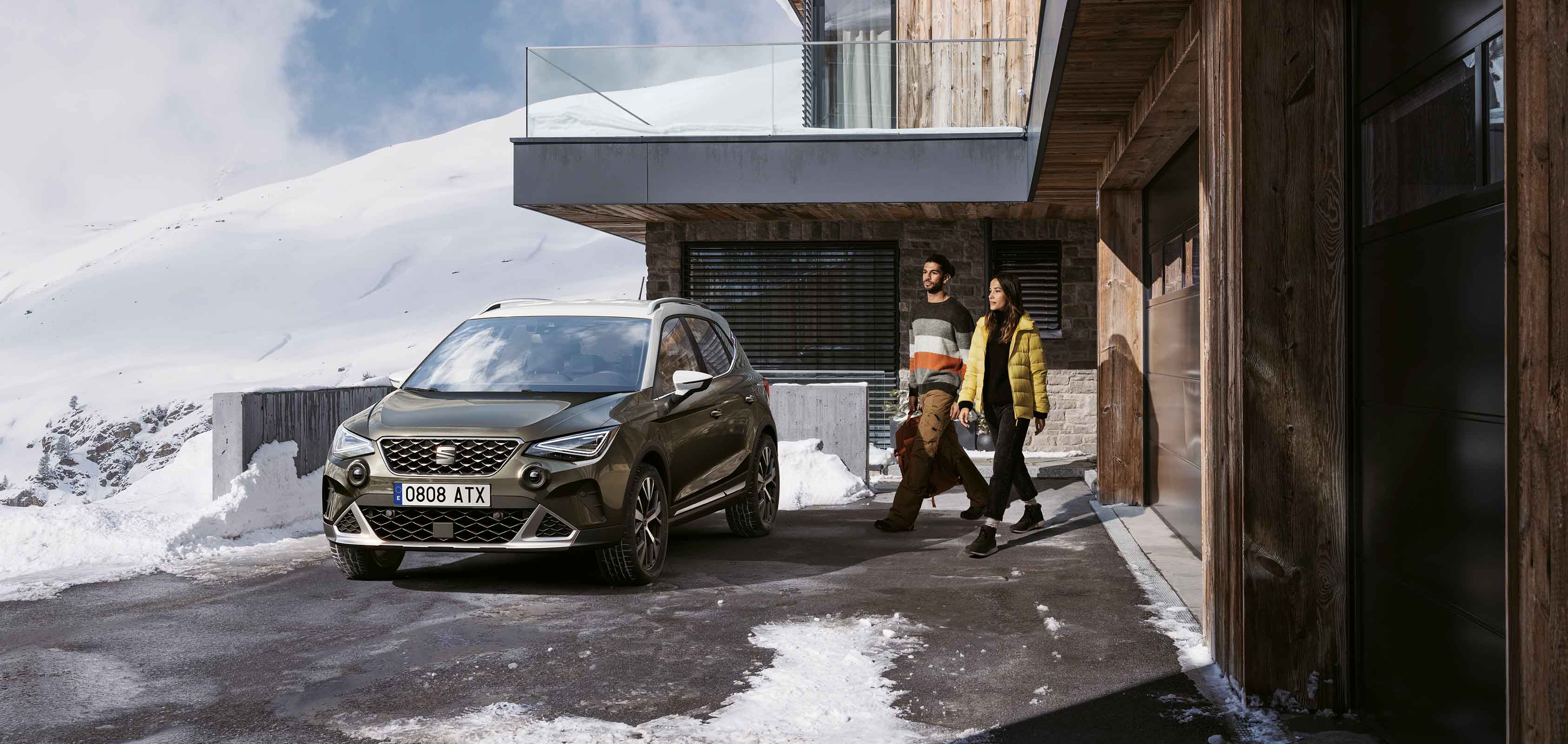 Seat ateca, one of seat’s end of life vehicles (elvs) parked outside wooden building by two models. 